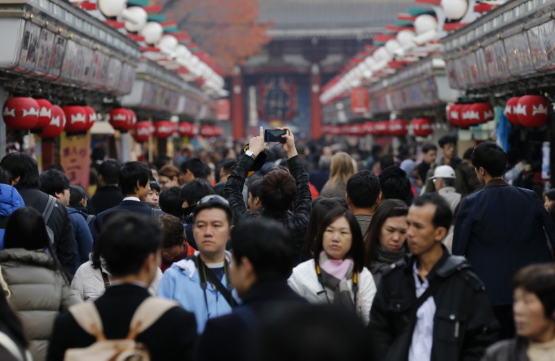 © Reuters. Visitor takes pictures of Nakamise shopping street on Asakusa district in Tokyo