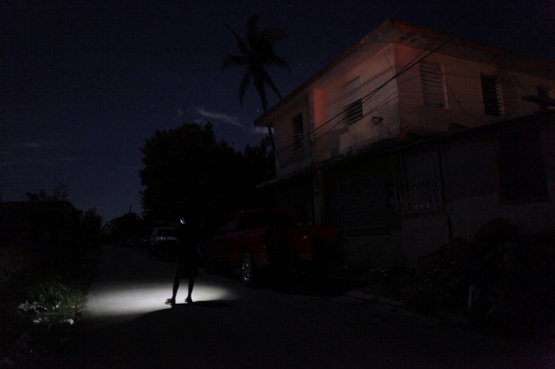 © Reuters. A man tries to use his mobile phone outside his home in Dorado