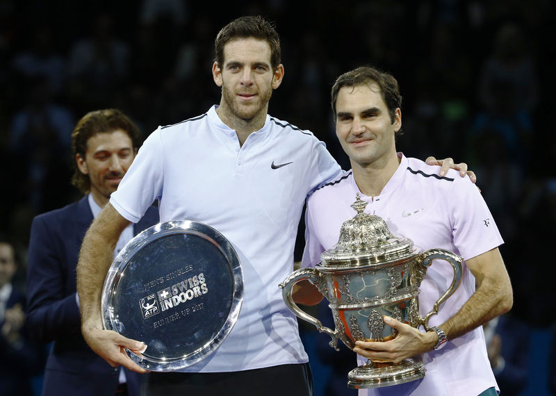 © Reuters. El argentino Juan Martín del Potro y el suizo Roger Federer posan con sus trofeos después de la final del Abierto de Basilea