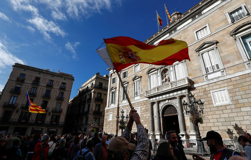 © Reuters. Spanish and Catalan separatist flags are waved in front of the Generalitat Palace, the Catalan regional government headquarters in Barcelona