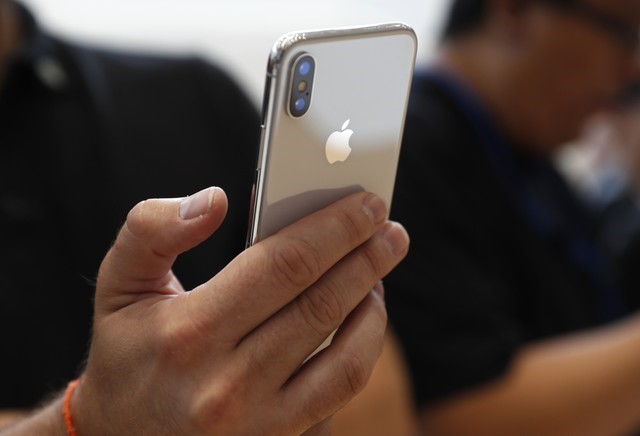 © Reuters. FILE PHOTO: An attendee checks out new iPhone X during an Apple launch event in Cupertino