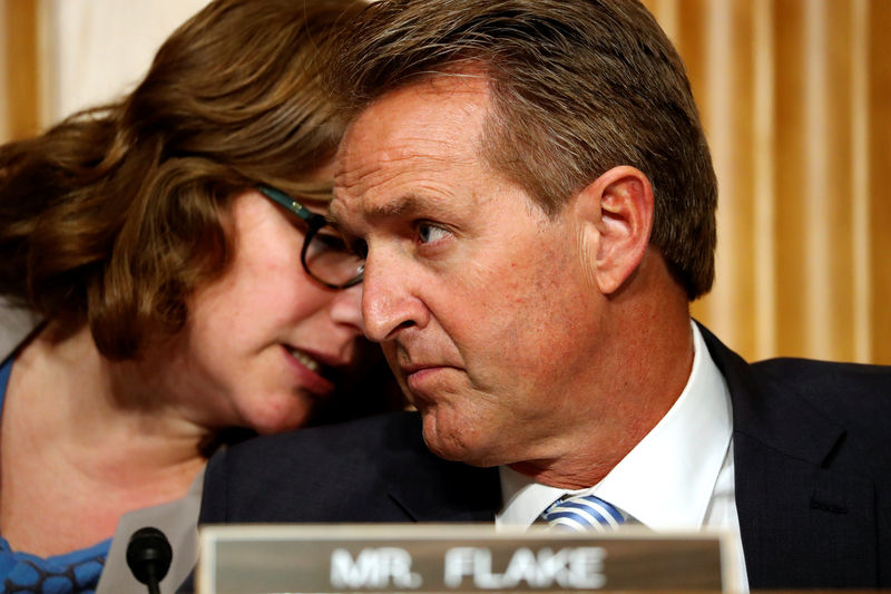 © Reuters. An aide speaks to U.S. Senator Jeff Flake (R-AZ) while he participates as Defense Secretary James Mattis and Secretary of State Rex Tillerson testify in Washington