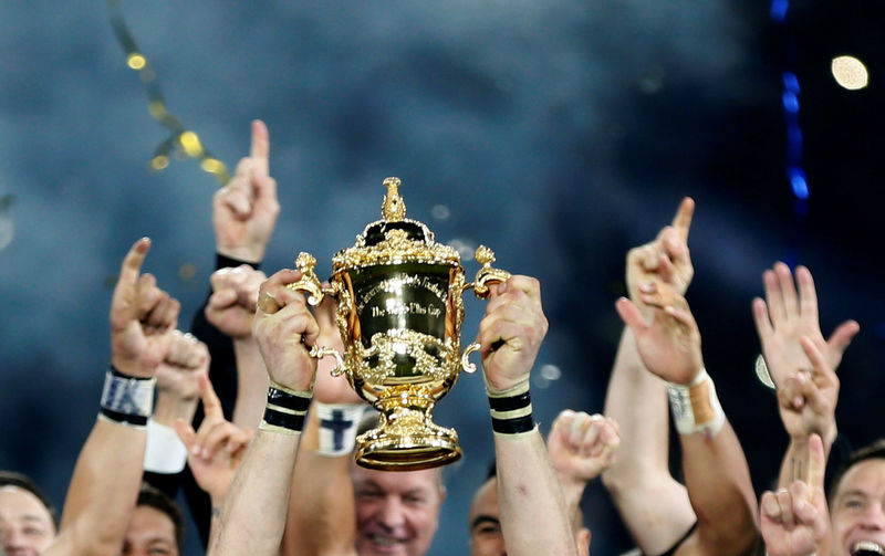 © Reuters. FILE PHOTO: New Zealand's team celebrates with the Webb Ellis trophy after winning the Rugby World Cup Final against Australia at Twickenham in London