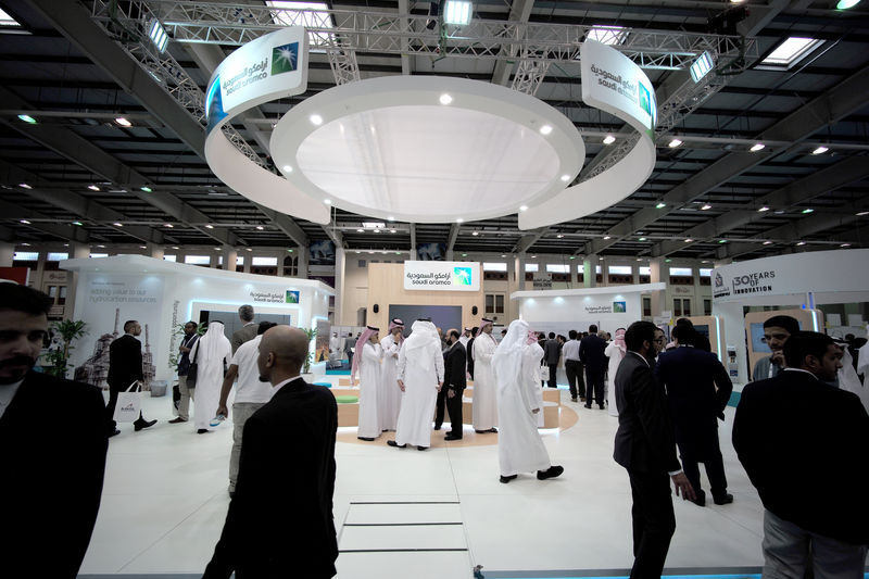 © Reuters. FILE PHOTO: Visitors are seen at the Saudi Aramco stand at the Middle East Process Engineering Conference & Exhibition in Manama