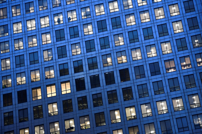 © Reuters. FILE PHOTO: Office lights are on at dusk in the Canary Wharf financial district, London