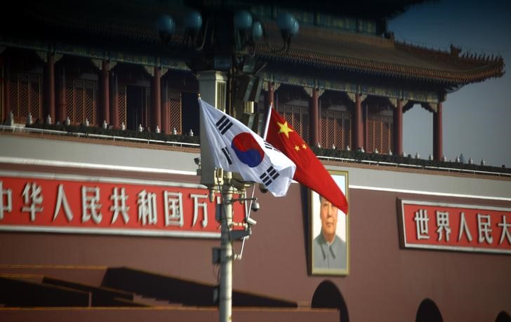 © Reuters. South Korean and Chinese national flags hang from a pole in front of the portrait of former Chinese chairman Mao Zedong at Beijing's Tiananmen Square