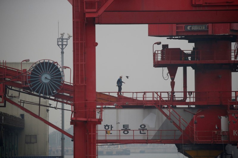 © Reuters. FILE PHOTO: An employee walks on a crane at a container terminal at Incheon port in Incheon