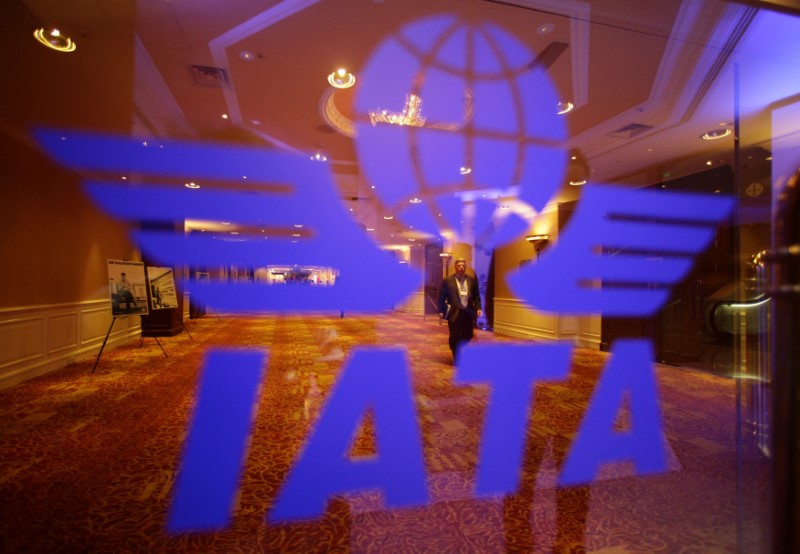 © Reuters. FILE PHOTO: A delegate of the 68th International Air Transport Association (IATA) annual general meeting is pictured through an IATA logo in Beijing