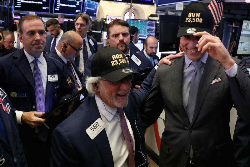 © Reuters. Thomas Farley, president of the New York Stock Exchange, laughs with trader Peter Tuchman as they wear hats to celebrate the DJIA rising above 23,500 on the floor of the New York Stock Exchange in New York