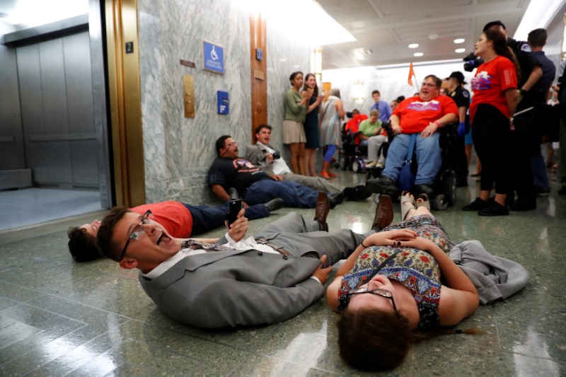 © Reuters. Demonstrators like on the ground as the Senate Finance Committee holds a hearing on the latest Republican Effort to repeal and replace the Affordable Care Act on Capitol Hill in Washington