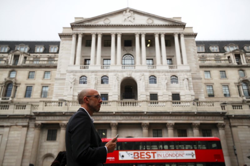 © Reuters. A man holds his mobile phone outside the Bank of England in London