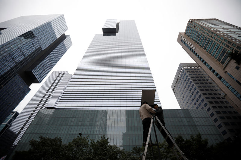 © Reuters. Workers work on a streetlight in front of a Samsung Electronics office building in Seoul