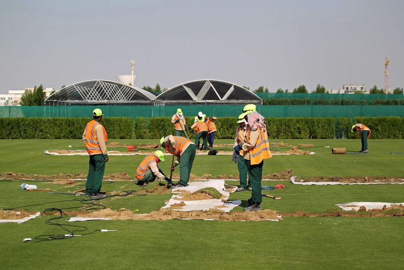 © Reuters. FILE PHOTO: Workers test soil as they grow grass for Qatar's 2022 World Cup, at an experimental facility in Doha