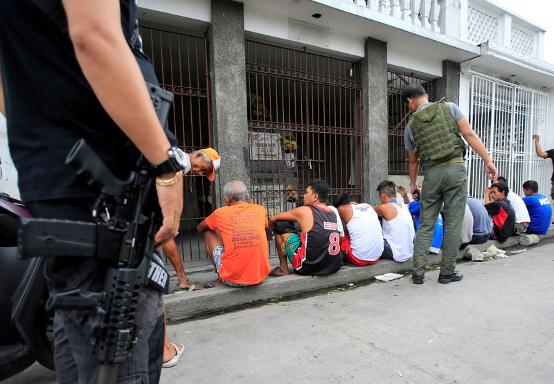 © Reuters. FILE PHOTO: Members of the Philippine Drug Enforcement Agency (PDEA) operatives inspects suspected drug pushers and users during their anti-drug operaitons inside the cemetery in Quezon city