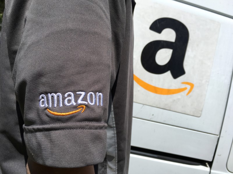 © Reuters. An Amazon.com Inc driver stands next to an Amazon delivery truck in Los Angeles