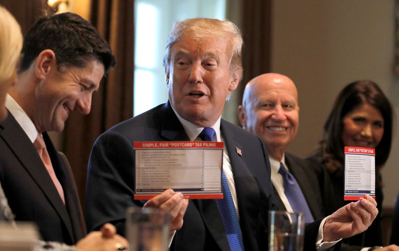 © Reuters. U.S. President Trump holds sample tax forms as he promotes tax plan at the White House in Washington