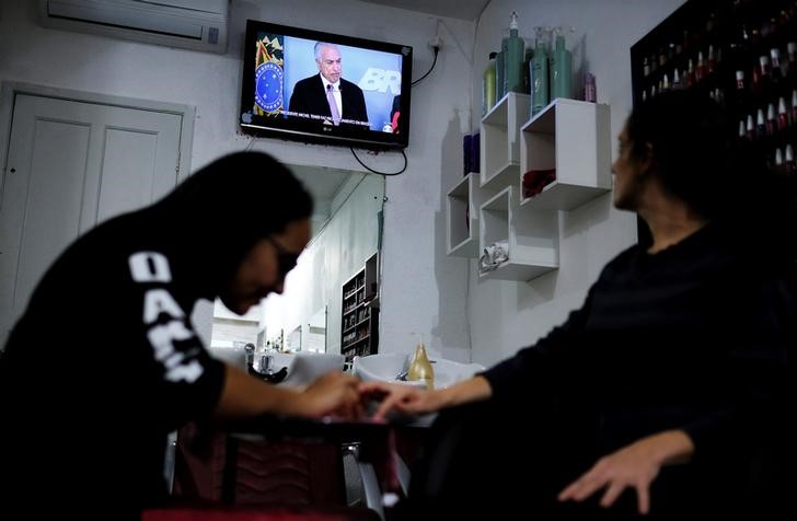 © Reuters. Mulheres assistem a discurso do presidente Michel Temer em salão de beleza em São Paulo