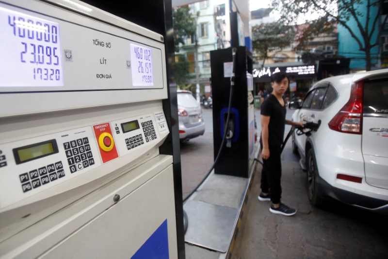 © Reuters. FILE PHOTO: A man pumps petrol for his car at a petrol station in Hanoi