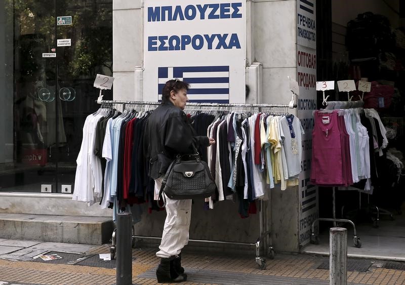 © Reuters. A woman looks at clothes on sale outside a shop in Athens