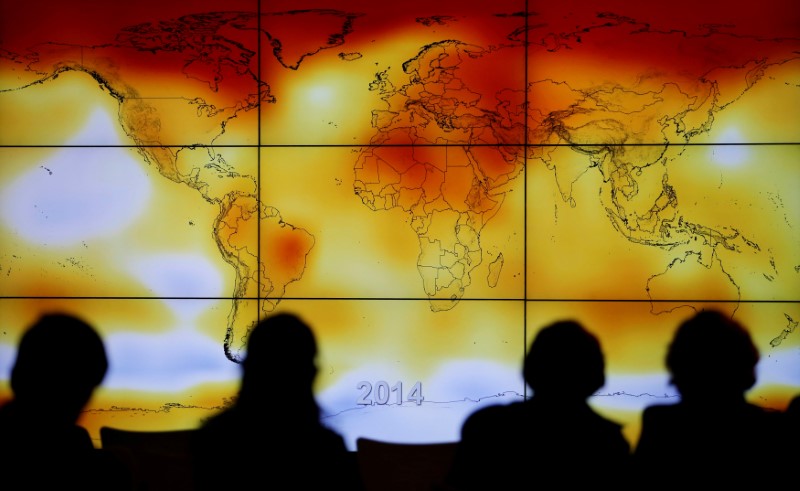 © Reuters. FILE PHOTO: Participants looks at a screen projecting a world map with climate anomalies during the World Climate Change Conference 2015 (COP21) at Le Bourget