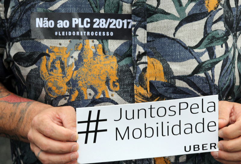 © Reuters. Motorista do Uber segura cartaz de protesto durante manifestação contra projeto de lei em São Paulo, Brasil