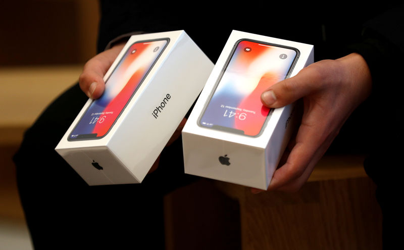 © Reuters. FILE PHOTO: A man holds two boxes for the Apple's new iPhone X at the Apple Store in Regents Street in London