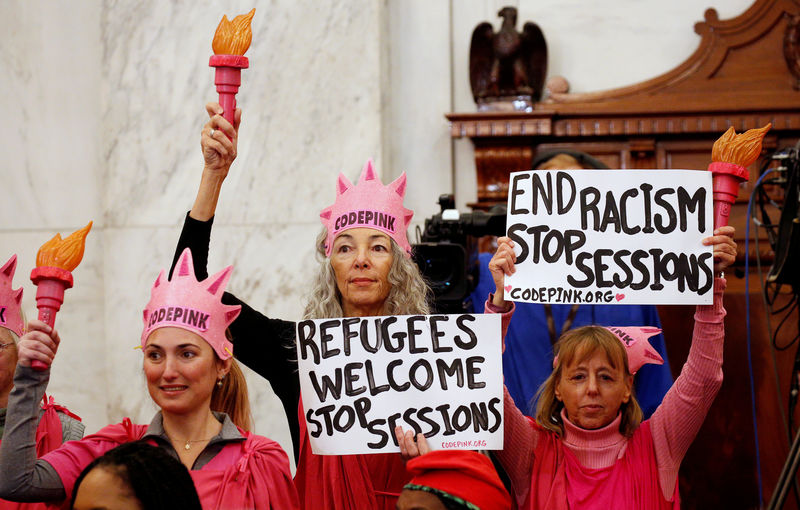 © Reuters. FILE PHOTO:      Protesters hold signs at Jeff Sessions confirmation hearing to become U.S. attorney general