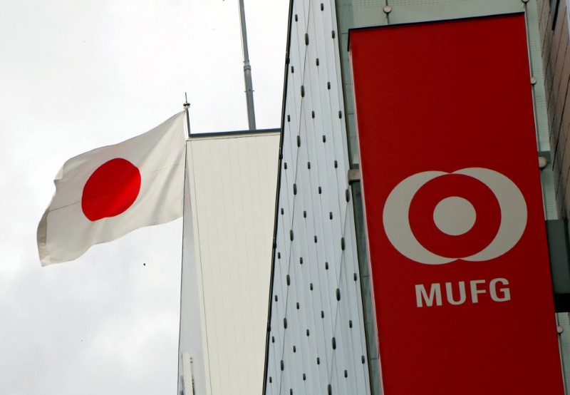 © Reuters. FILE PHOTO: Japan's national flag is seen behind the logo of  Mitsubishi UFJ Financial Group Inc (MUFG) at its bank branch in Tokyo