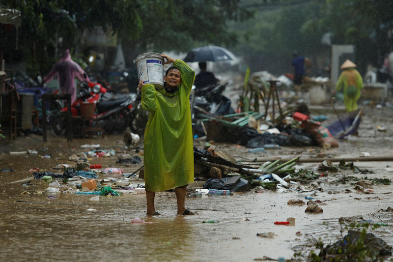 © Reuters. Pessoas limpam rua após enchentes causadas pelo tufão Damrey na cidade de Hoi An, no Vietnã