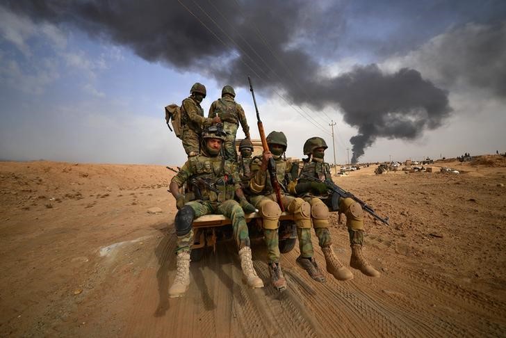 © Reuters. Shi'ite Popular Mobilization Forces (PMF) advance towards the city of Al-Qaim