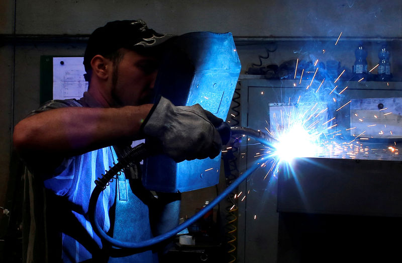 © Reuters. FILE PHOTO: A worker welds in a factory in Gravellona Lomellina, southwest of Milan