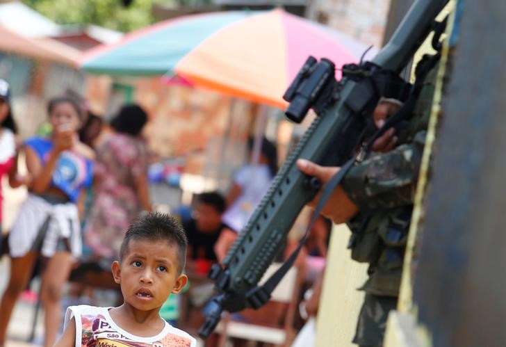 © Reuters. Menino indígena observa soldado brasileiro durante exercício militar em Tabatinga