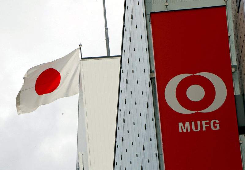 © Reuters. FILE PHOTO: Japan's national flag is seen behind the logo of  Mitsubishi UFJ Financial Group Inc (MUFG) at its bank branch in Tokyo