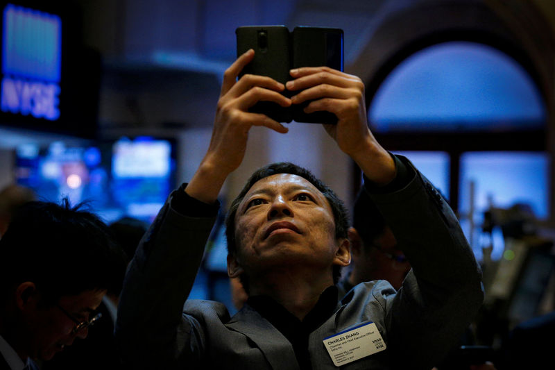 © Reuters. Chairman Charles Zhang of China-based Sogou Inc uses his phone to take a photo during his company's IPO at the NYSE in New York
