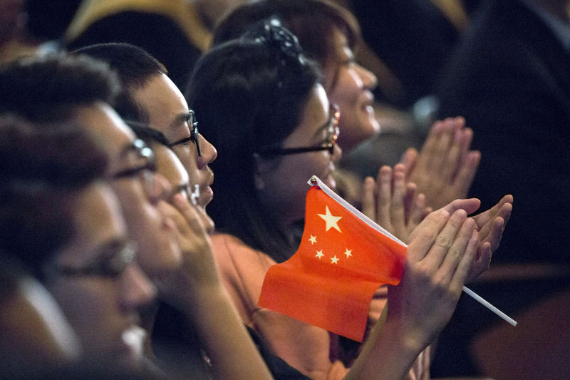 © Reuters. FILE PHOTO: Students clap while Chinese President Xi Jinping delivers a speech during a visit to Lincoln High School in Tacoma, Washington