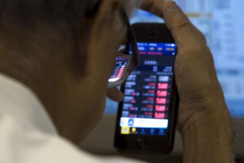 © Reuters. An investor monitors share prices inside a brokerage firm during morning trading in Hong Kong, China