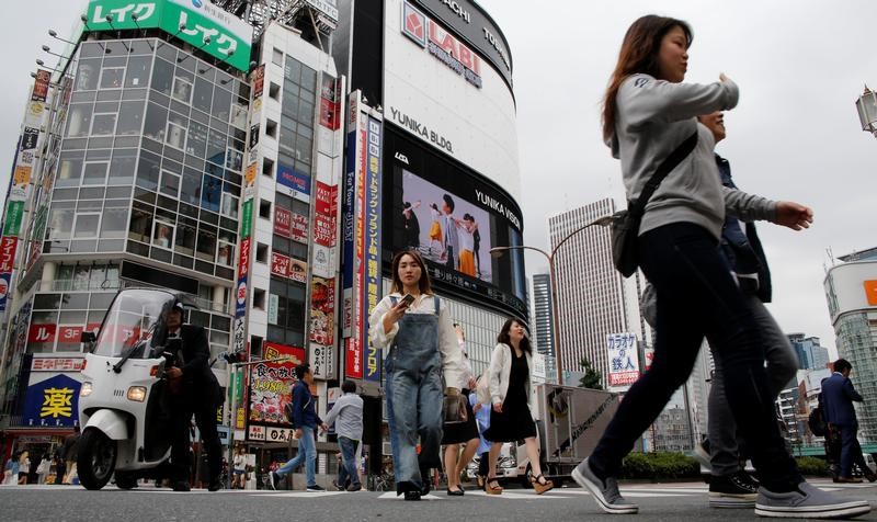 © Reuters. People cross a street in the Shinjuku shopping and business district in Tokyo