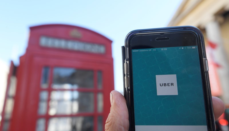 © Reuters. A photo illustration shows the Uber app logo displayed on a mobile telephone, as it is held up for a posed photograph in central London