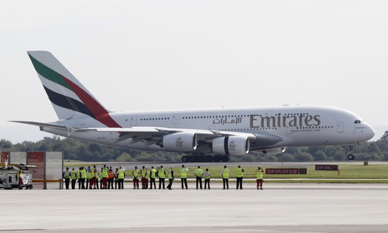 © Reuters. Airport staff watch as an Emirates Airbus A380-800 lands at Manchester Airport