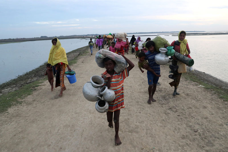 © Reuters. Rohingya refugees walk after crossing the Naf River in Teknaf