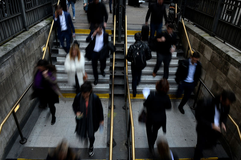 © Reuters. FILE PHOTO - City workers make their way home in the City of London