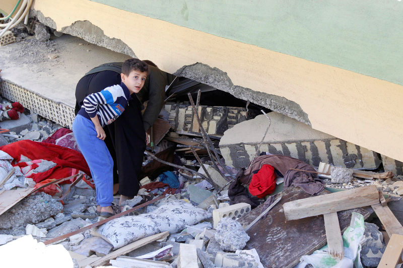 © Reuters. Homem vasculha destroços de prédio que desabou devido ao terremoto na cidade de Darbandikhan