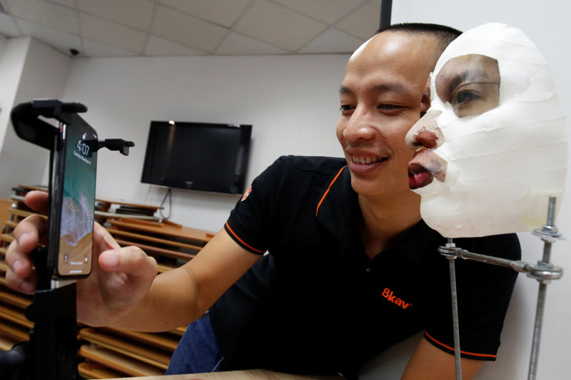 © Reuters. Vice-presidente da Bkav, empresa de cibersegurança vietnamita, Ngo Tuan Anh, demostra software de reconhecimento facial do iPhone X com máscara 3D em Hanói, Vietnã