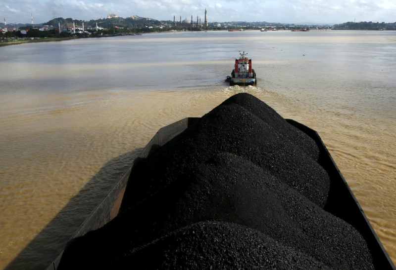 © Reuters. A tug boat pulls a coal barge along the Mahakam River in Samarinda