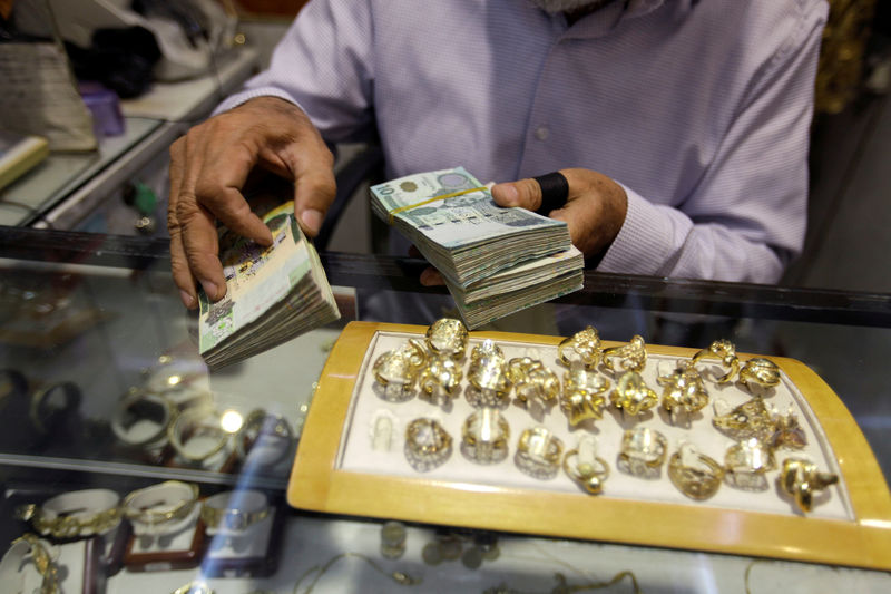 © Reuters. A man displays Libyan Dinar banknotes in a jewellery store in the old city of Tripoli
