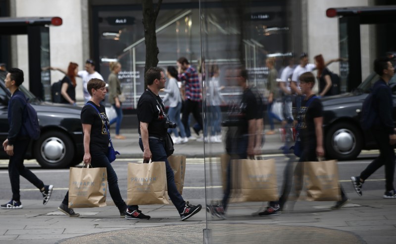 © Reuters. Shoppers are reflected in a window as they walk along Oxford Street in London