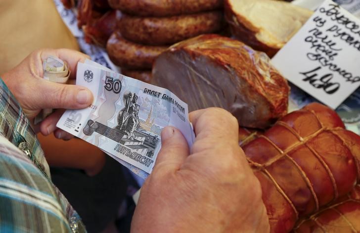 © Reuters. Покупатель расплачивается на рынке в Красноярске