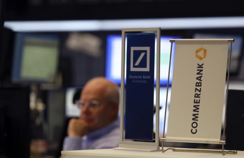 © Reuters. Banners of Deutsche Bank and Commerzbank are pictured in front of a trader at the stock exchange in Frankfurt