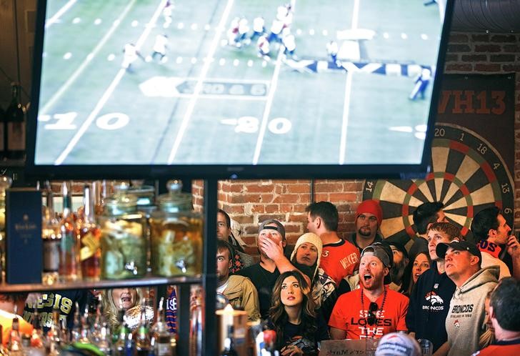 © Reuters. FILE PHOTO - Broncos fans react to a play while watching their team's NFL Super Bowl XLVIII football game against the Seahawks at a bar in Denver