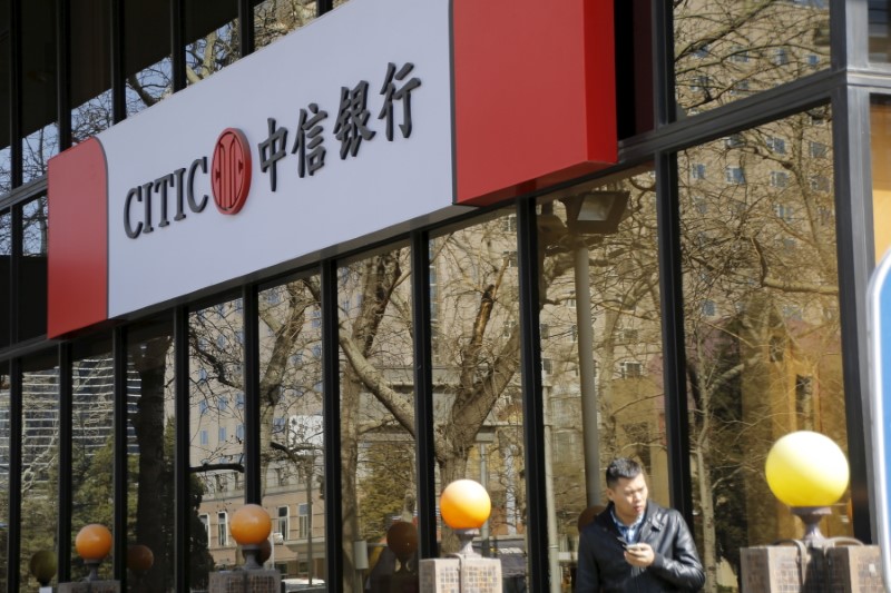 © Reuters. A man stands in front of CITIC bank's branch in Beijing